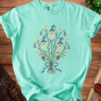 Mint t-shirt with three ghosts in wizard hats and floral elements.