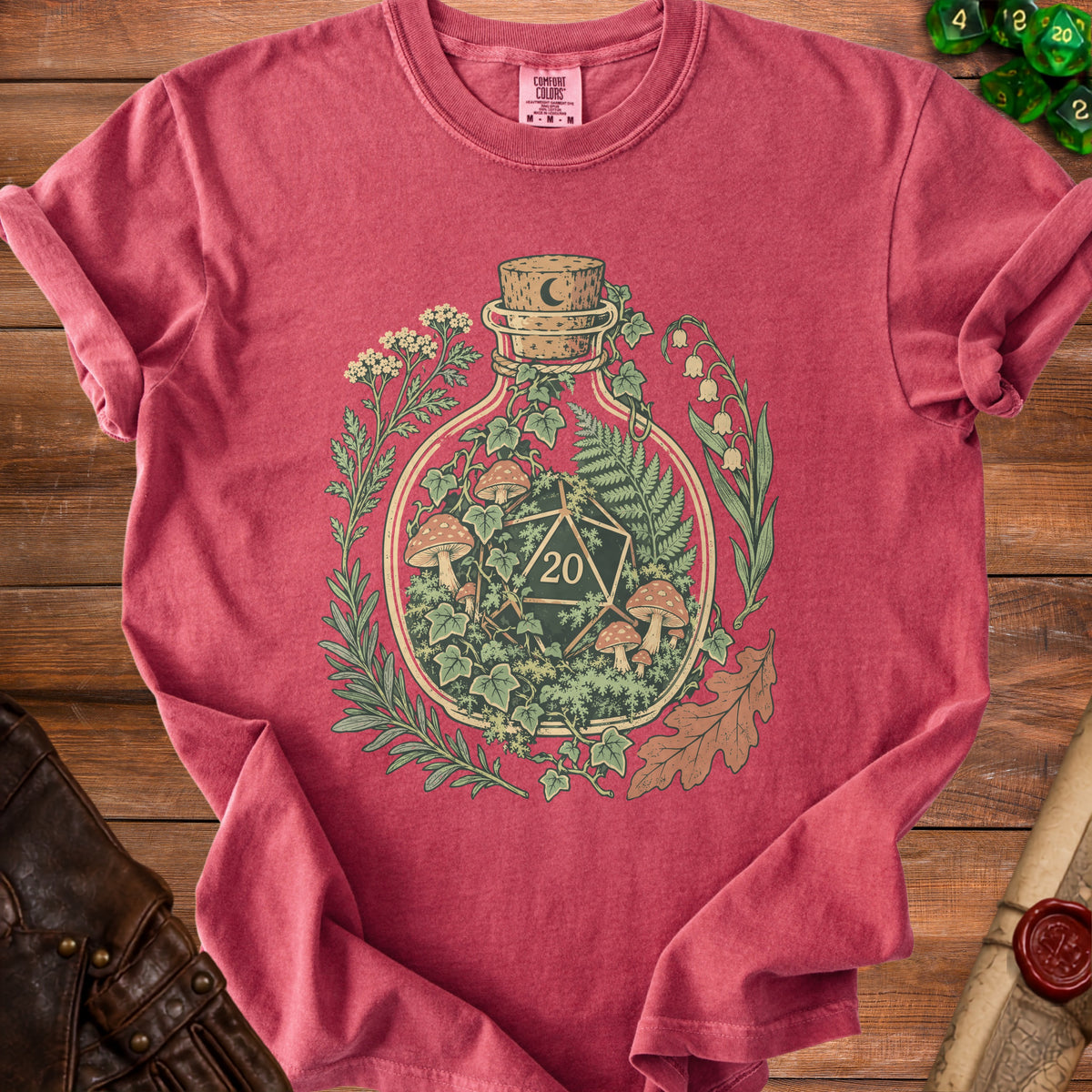 T-shirt with a potion bottle graphic featuring a D20 dice, mushrooms, and foliage.