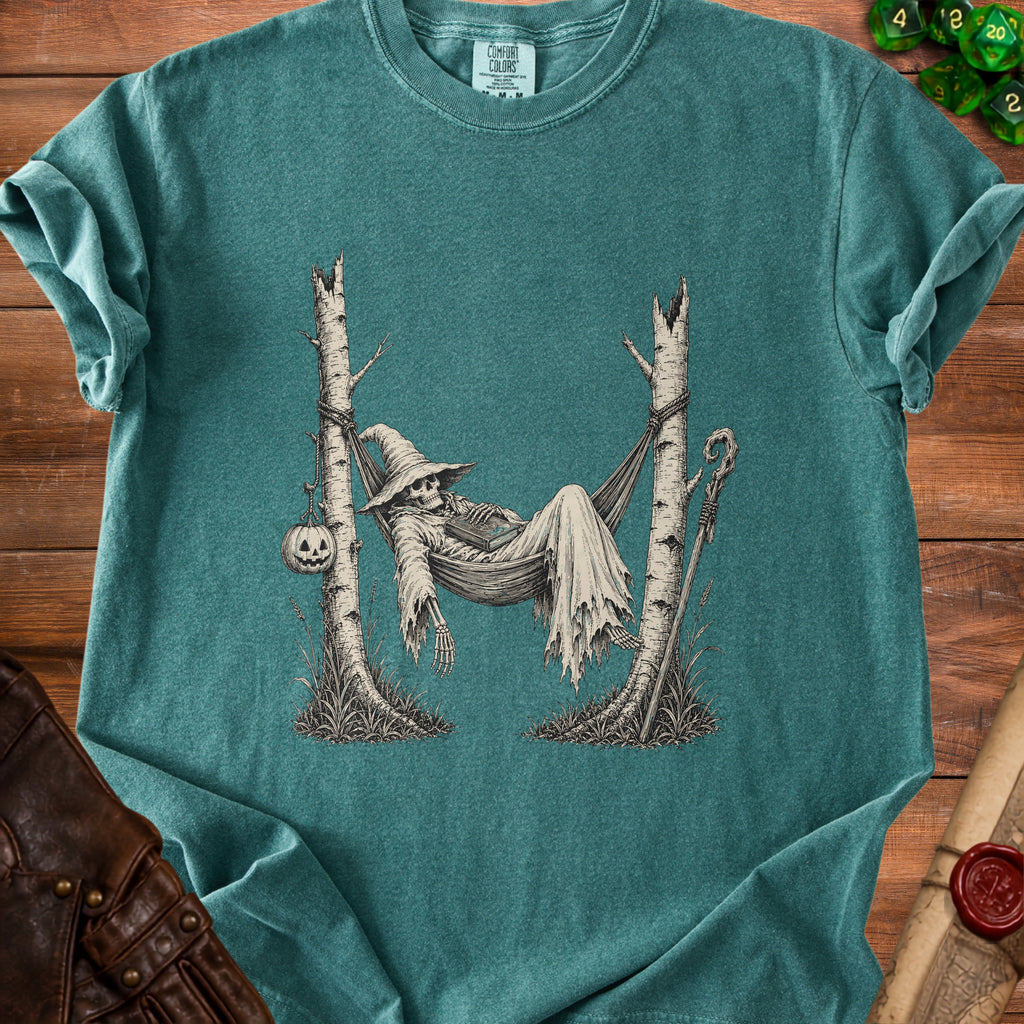 Skeleton in witch hat relaxing in a hammock between trees, with pumpkin.
