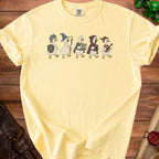 Five cartoon ducks in medieval fantasy costumes walk across a yellow t-shirt.