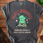 Dark grey t-shirt with a green goblin graphic and text "Reject Modernity Embrace Being a Silly Little Goblin".