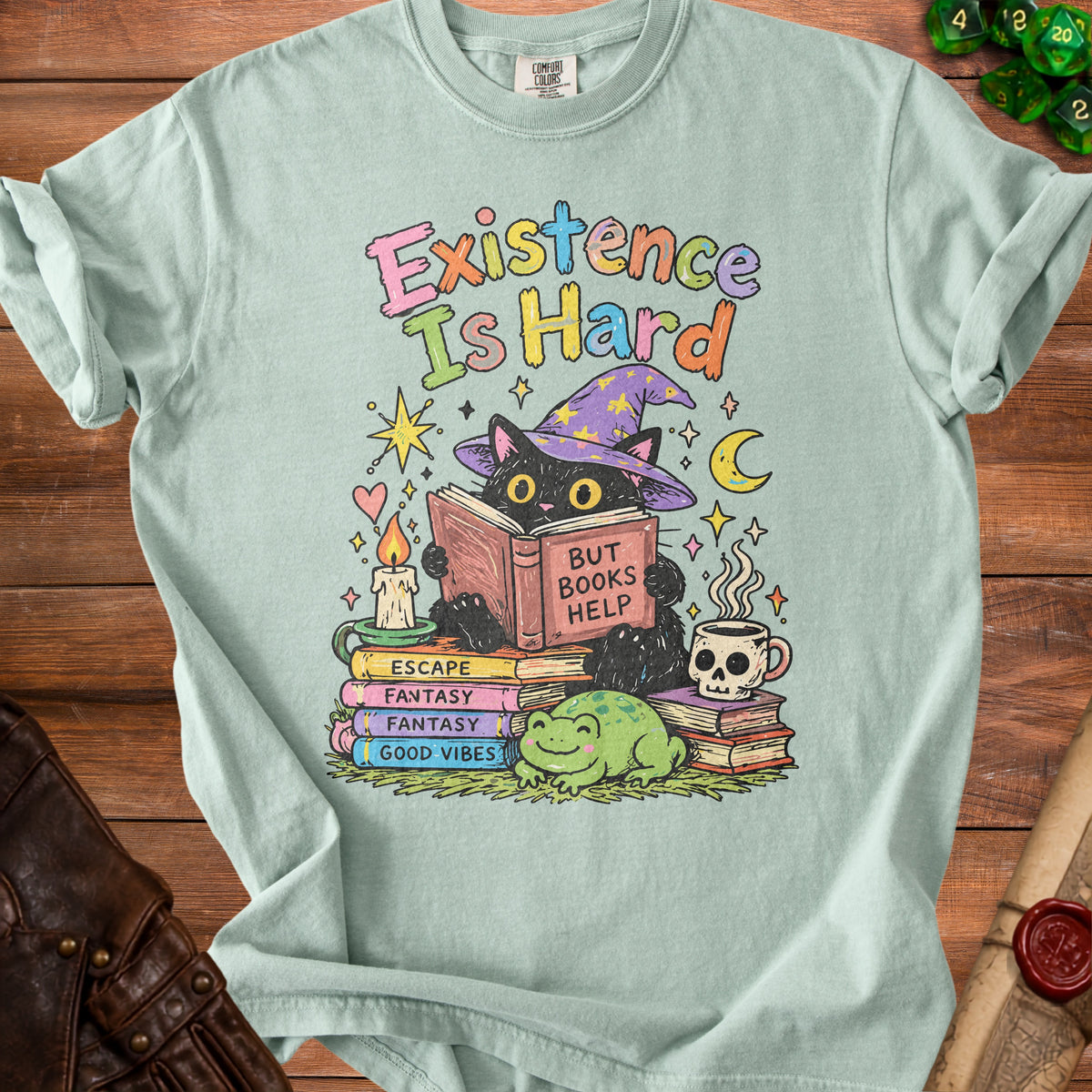 Black cat reading with "Existence Is Hard But Books Help" on light blue t-shirt.