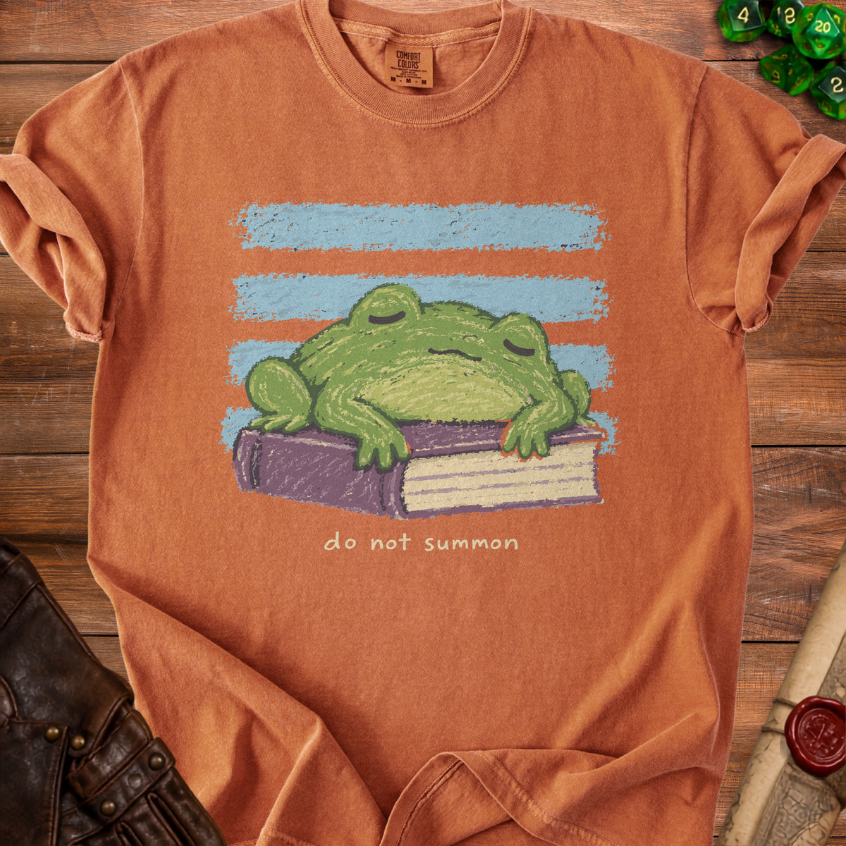 Orange Comfort Colors t-shirt with a sleeping frog on a book, text "do not summon".