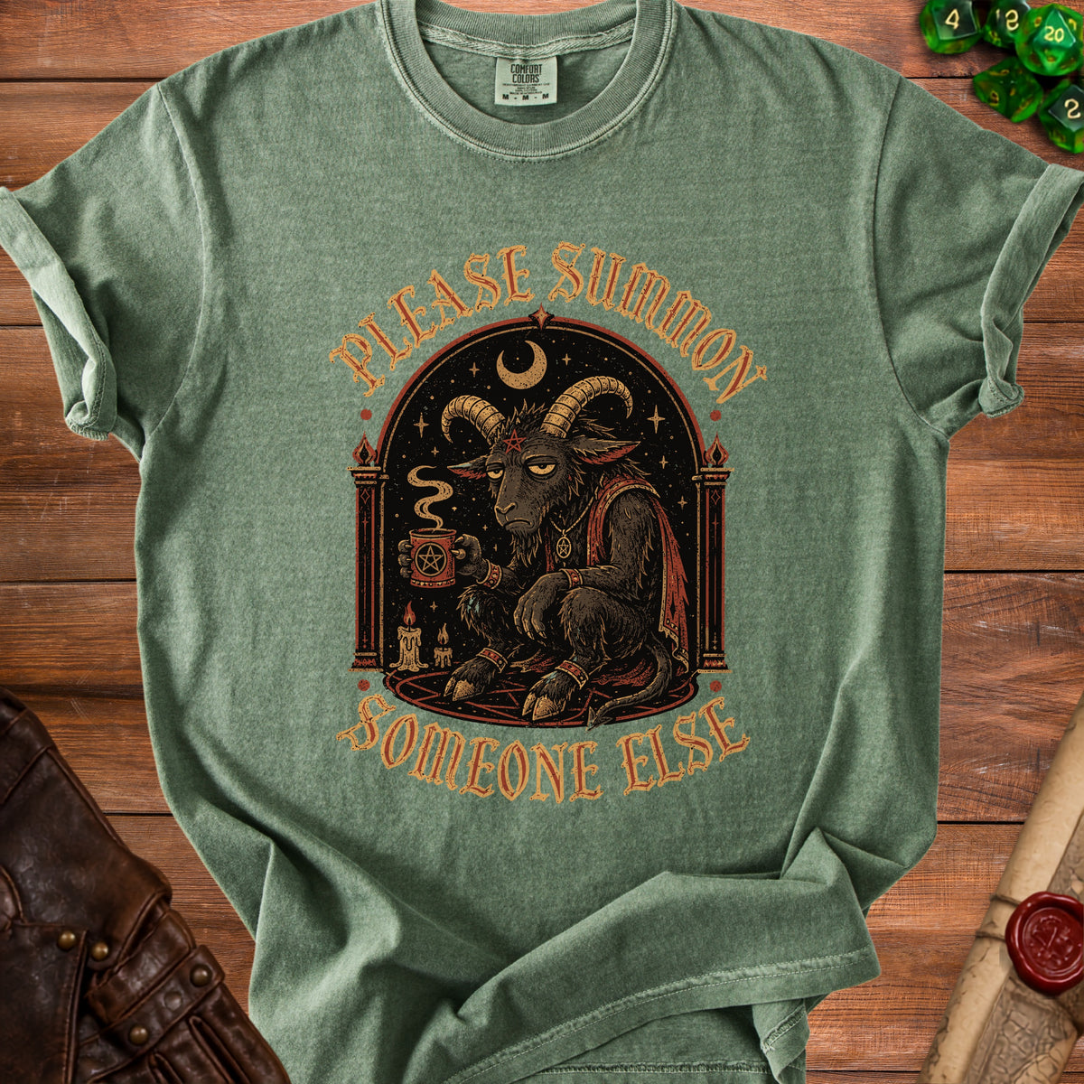 Green t-shirt with graphic of tired goat holding coffee and text "Please Summon Someone Else".