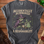 T-shirt with a frog wizard feeding a spiky creature, text "ACCIDENTALLY SUMMONED A RESPONSIBILITY".