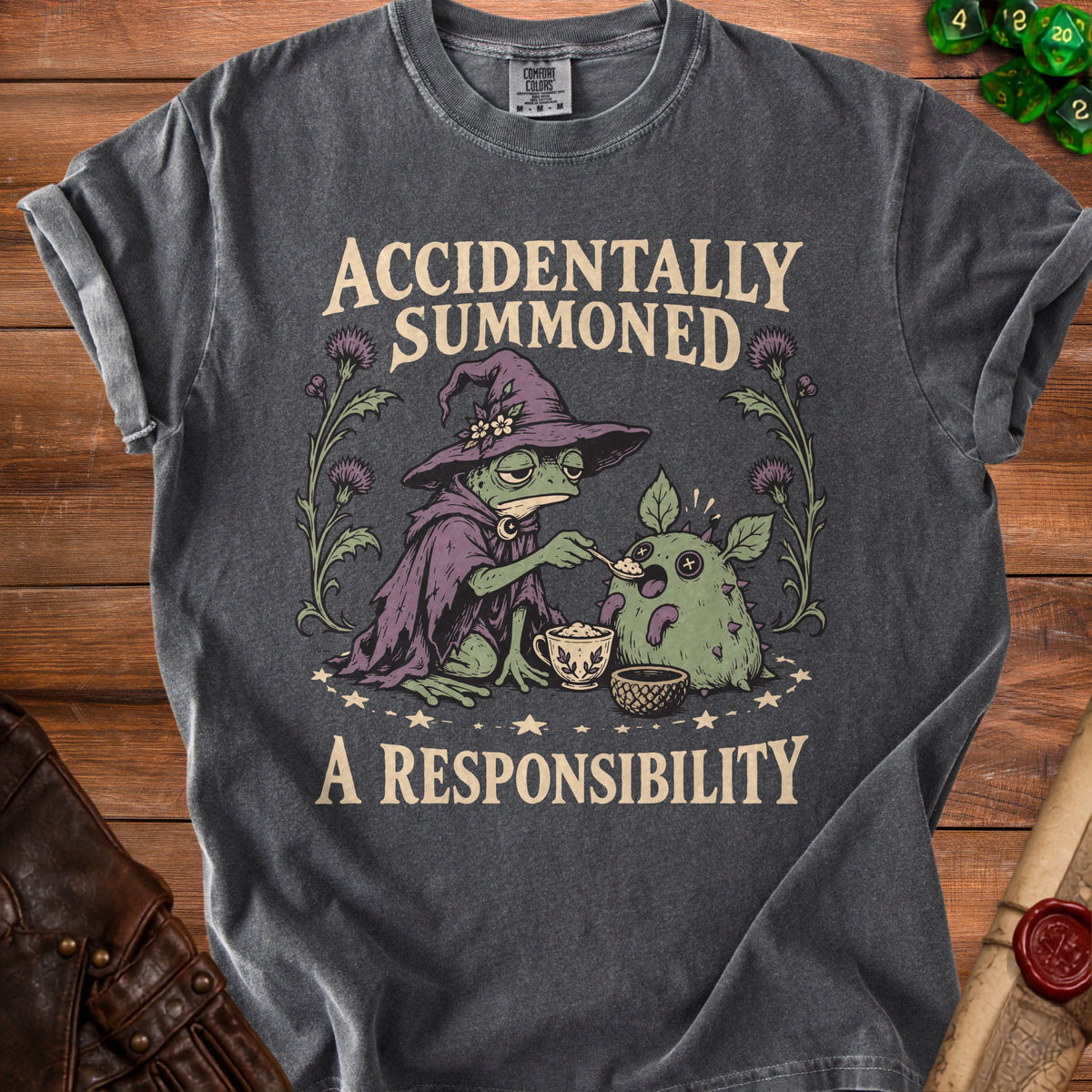 T-shirt with a frog wizard feeding a spiky creature, text "ACCIDENTALLY SUMMONED A RESPONSIBILITY".