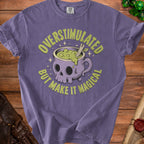 Purple t-shirt with text and graphic of a skull-shaped cauldron.