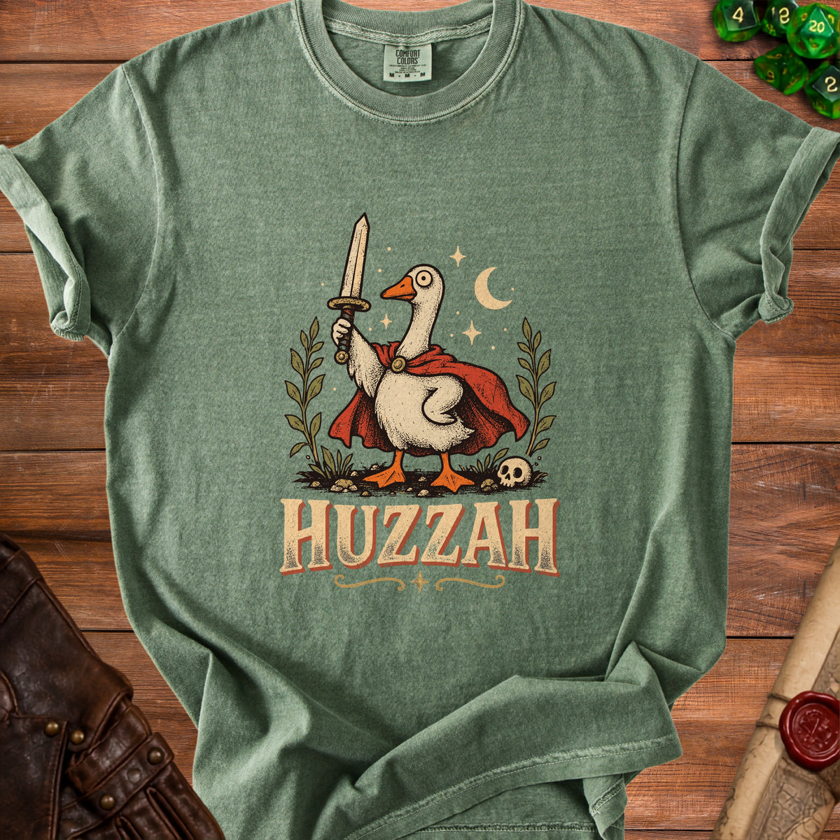 Green t-shirt with a goose wearing a cape holding a sword and the word HUZZAH.