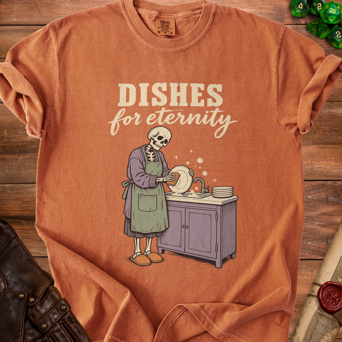 Skeleton washing dishes with text "Dishes for eternity" on an orange t-shirt.