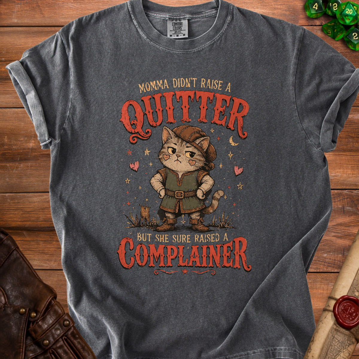 T-shirt with a cat wearing a hat and tunic that reads "Momma didn't raise a quitter, but she sure raised a complainer."