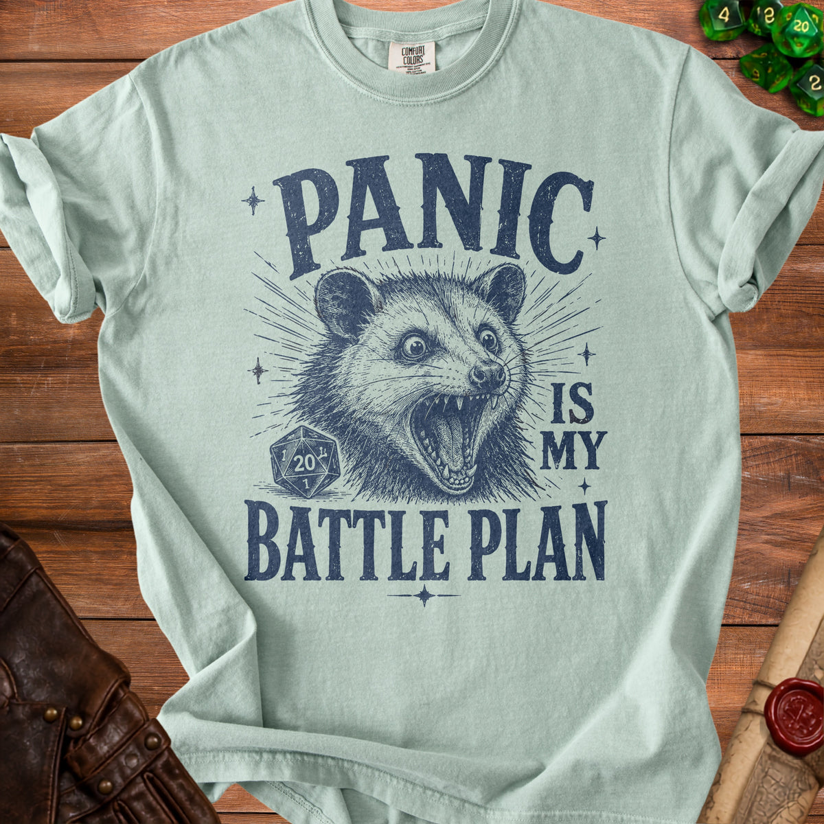 Light blue t-shirt with navy graphic of a screaming possum and text "PANIC IS MY BATTLE PLAN".