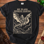 A black t-shirt features a vintage-style graphic of a woman riding a dragon above clouds, with the text MY PLANS INVOLVE LEAVING.