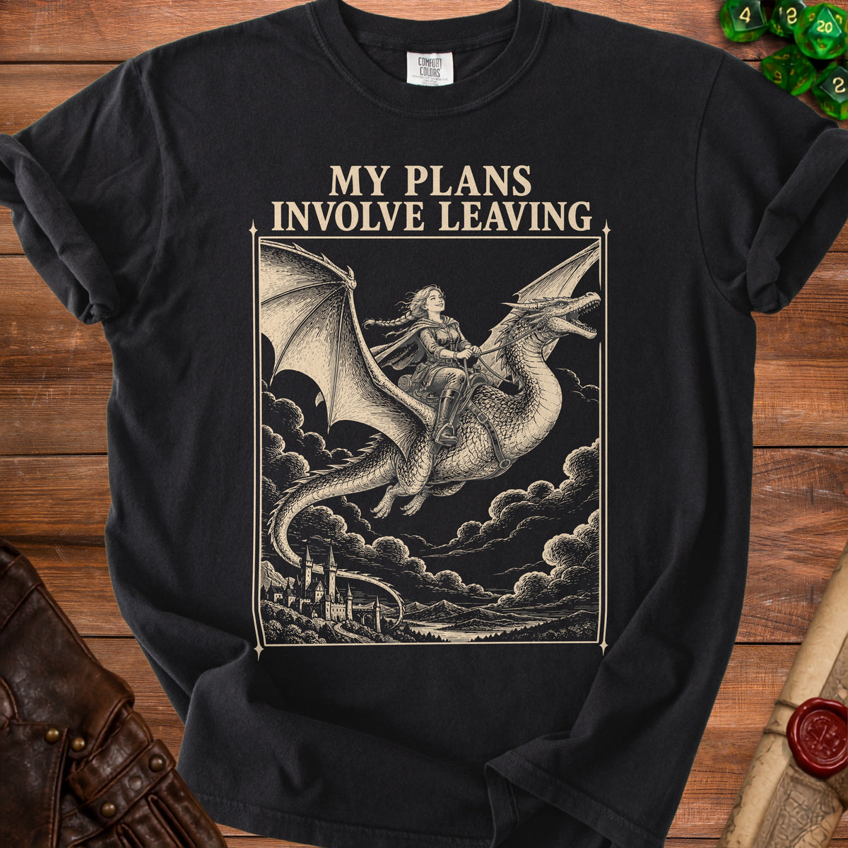 A black t-shirt features a vintage-style graphic of a woman riding a dragon above clouds, with the text MY PLANS INVOLVE LEAVING.