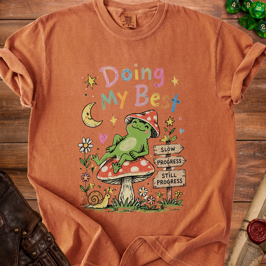 Orange t-shirt with frog on mushroom, moon, and text "Doing My Best".