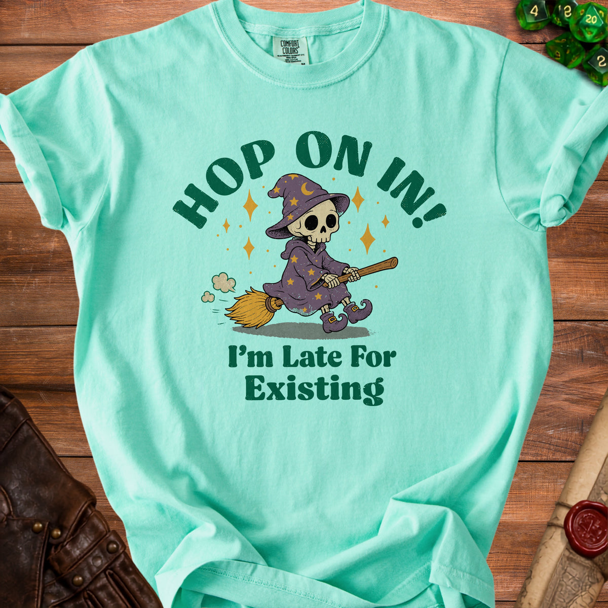 T-shirt with skeleton witch graphic saying "Hop On In!" and "I'm Late For Existing".