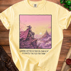 Yellow t-shirt with artwork of a knight overlooking a castle and text "Looking hotter in your 30s than in you' is exactly the flex you think".