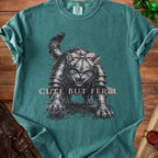 T-shirt with a grumpy cat in armor wearing a pink bow and the text "CUTE BUT FERAL".