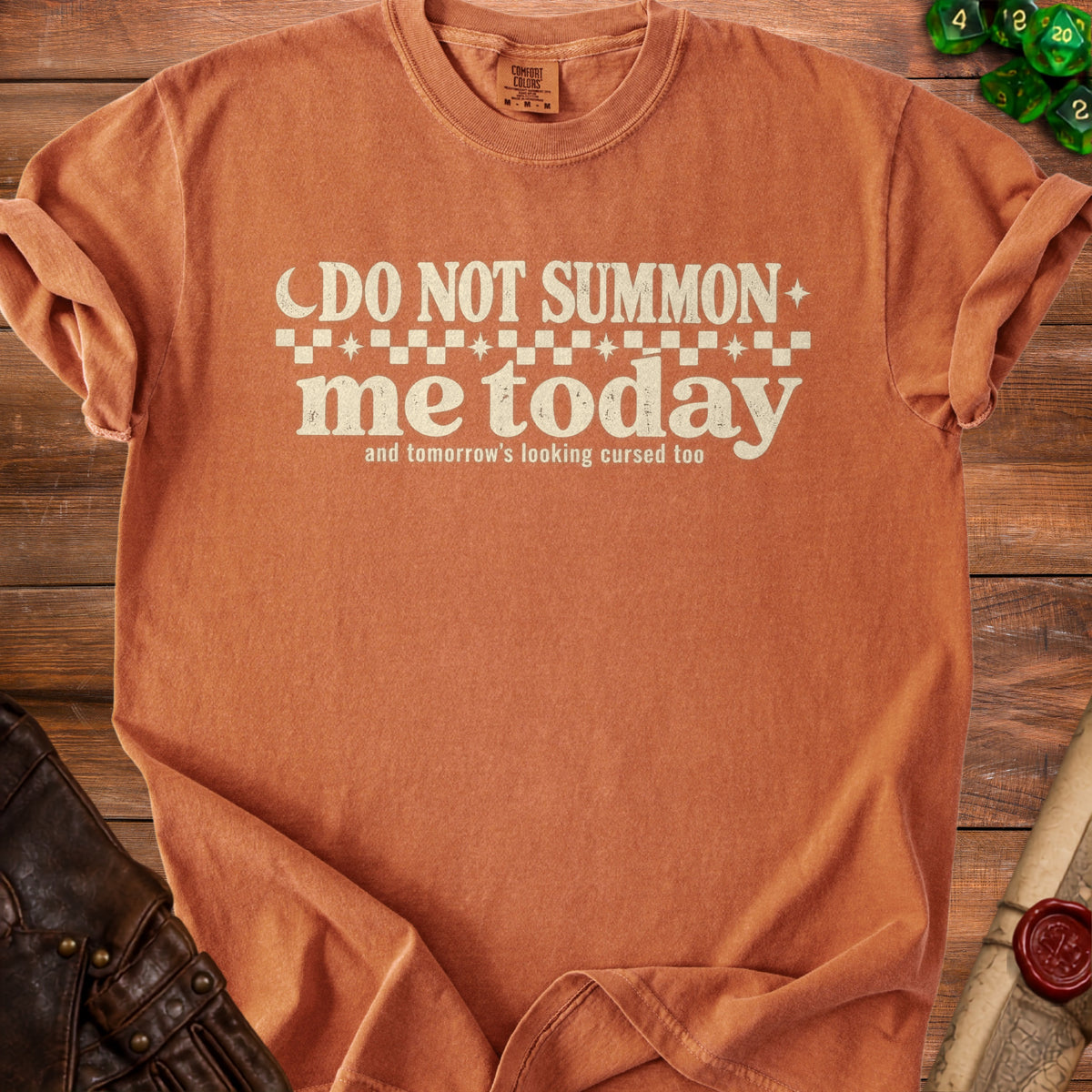 Orange t-shirt with "Do not summon me today" text and dice.