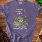 Purple t-shirt with graphic of a gnome and monkeys at a circus.
