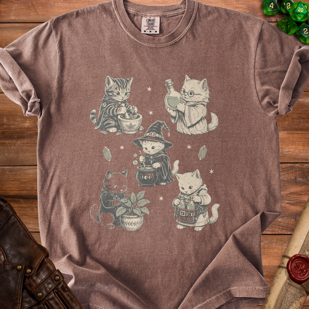 T-shirt with a print of five witchy cats brewing potions and tending plants.