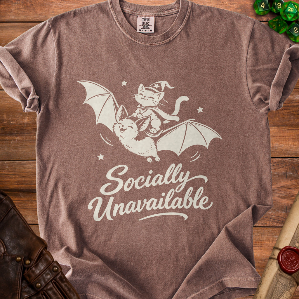 Brown t-shirt with white graphic of a cat riding a bat, reading "Socially Unavailable".