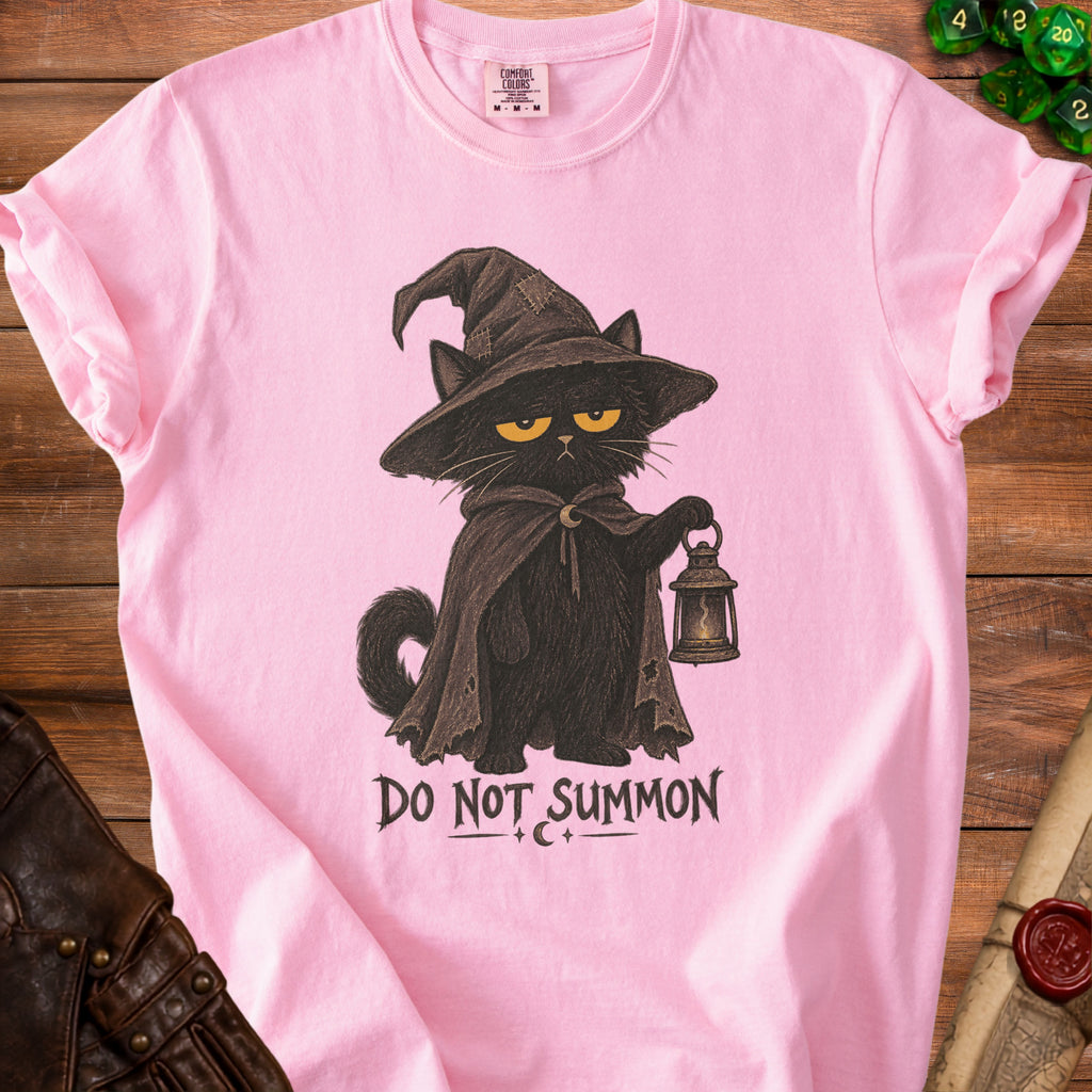 Pink t-shirt with a black cat in a witch hat holding a lantern and text "DO NOT SUMMON".