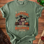 Green t-shirt with "I run on caffeine, trauma, and Halloween decor" text and spooky monster.