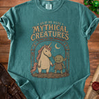 T-shirt with graphic of unicorn and goblin holding hands, "Mythical Creatures" text.