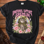 Black t-shirt with "Emotional Support Gremlin" text over a cat wearing a mushroom hat and surrounded by flowers.