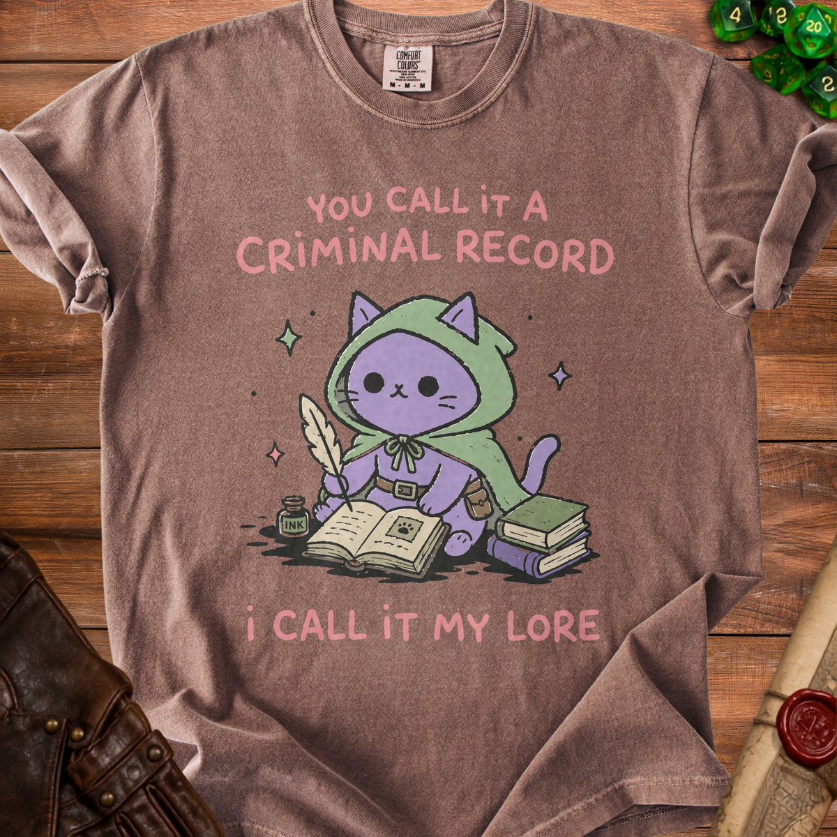 Brown t-shirt with purple cat character writing "You call it a criminal record, I call it my lore."