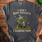 T-shirt with a green goblin sharpening an axe on a grindstone, text reads "I DON'T BURY HATCHETS I SHARPEN THEM".