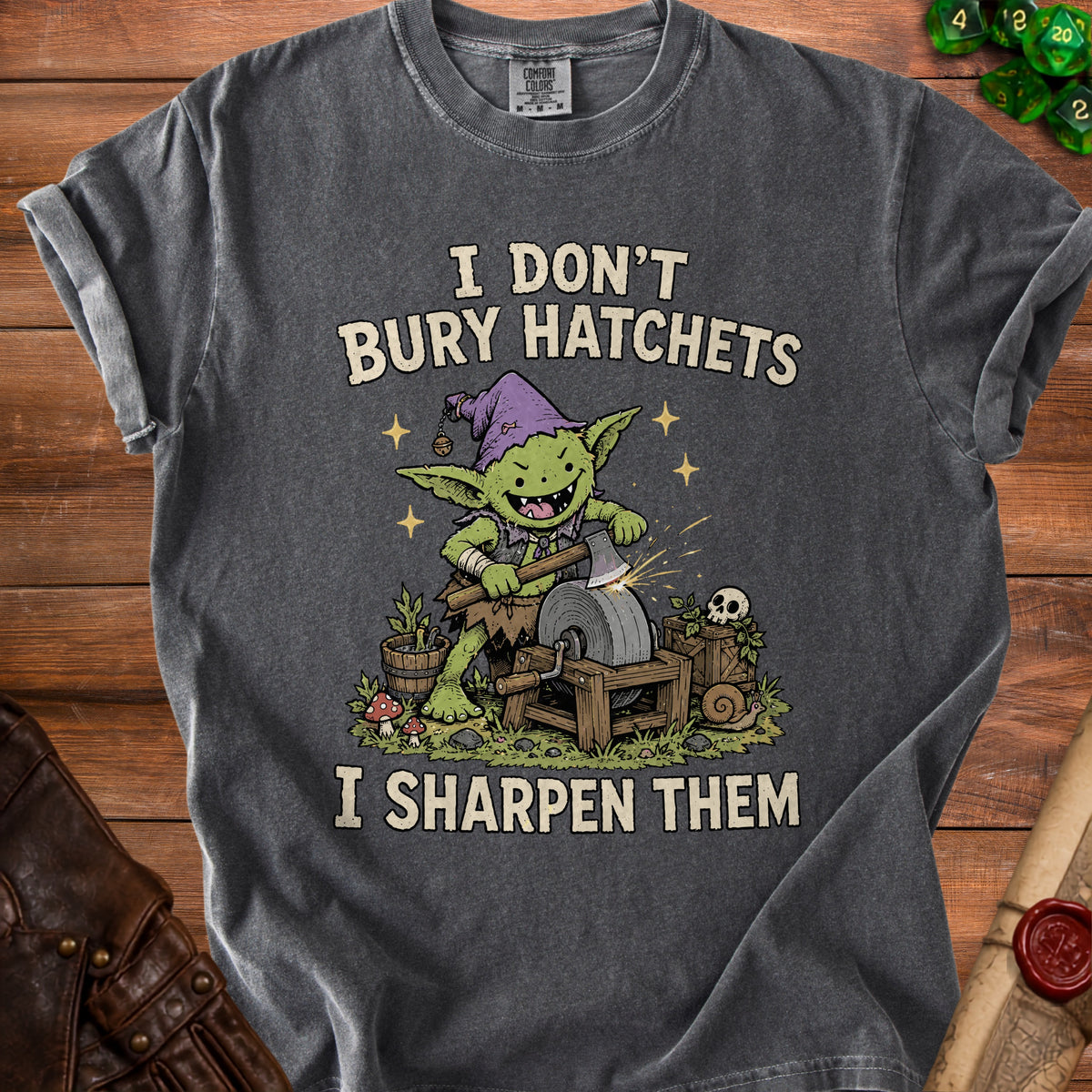 T-shirt with a green goblin sharpening an axe on a grindstone, text reads "I DON'T BURY HATCHETS I SHARPEN THEM".
