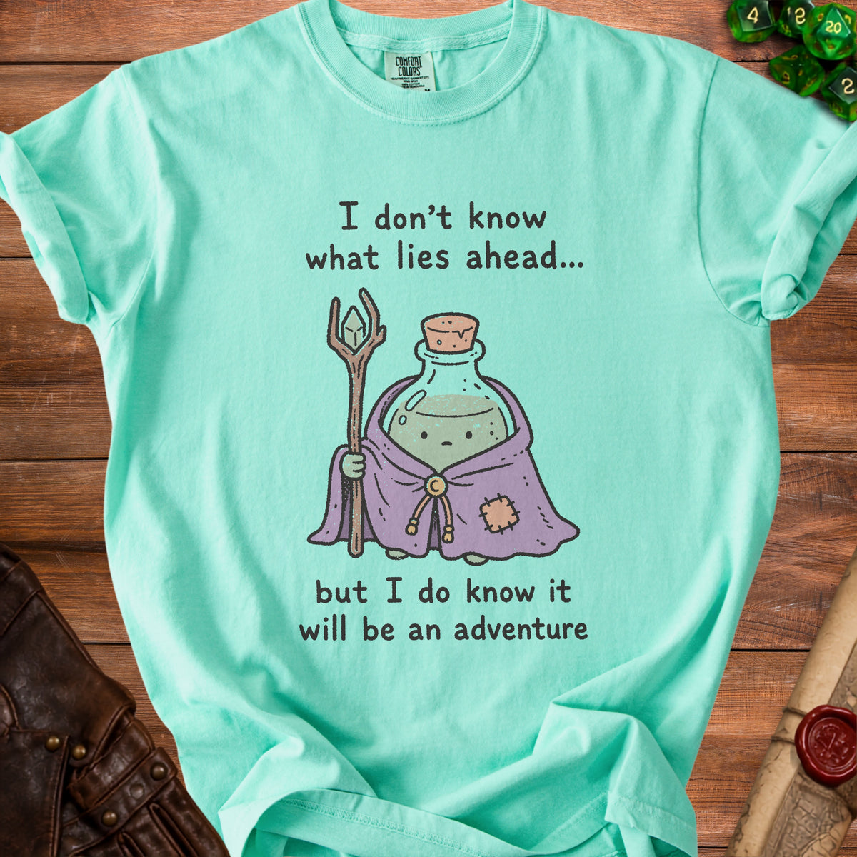 Teal t-shirt with potion, staff, and text: "I don't know what lies ahead..."