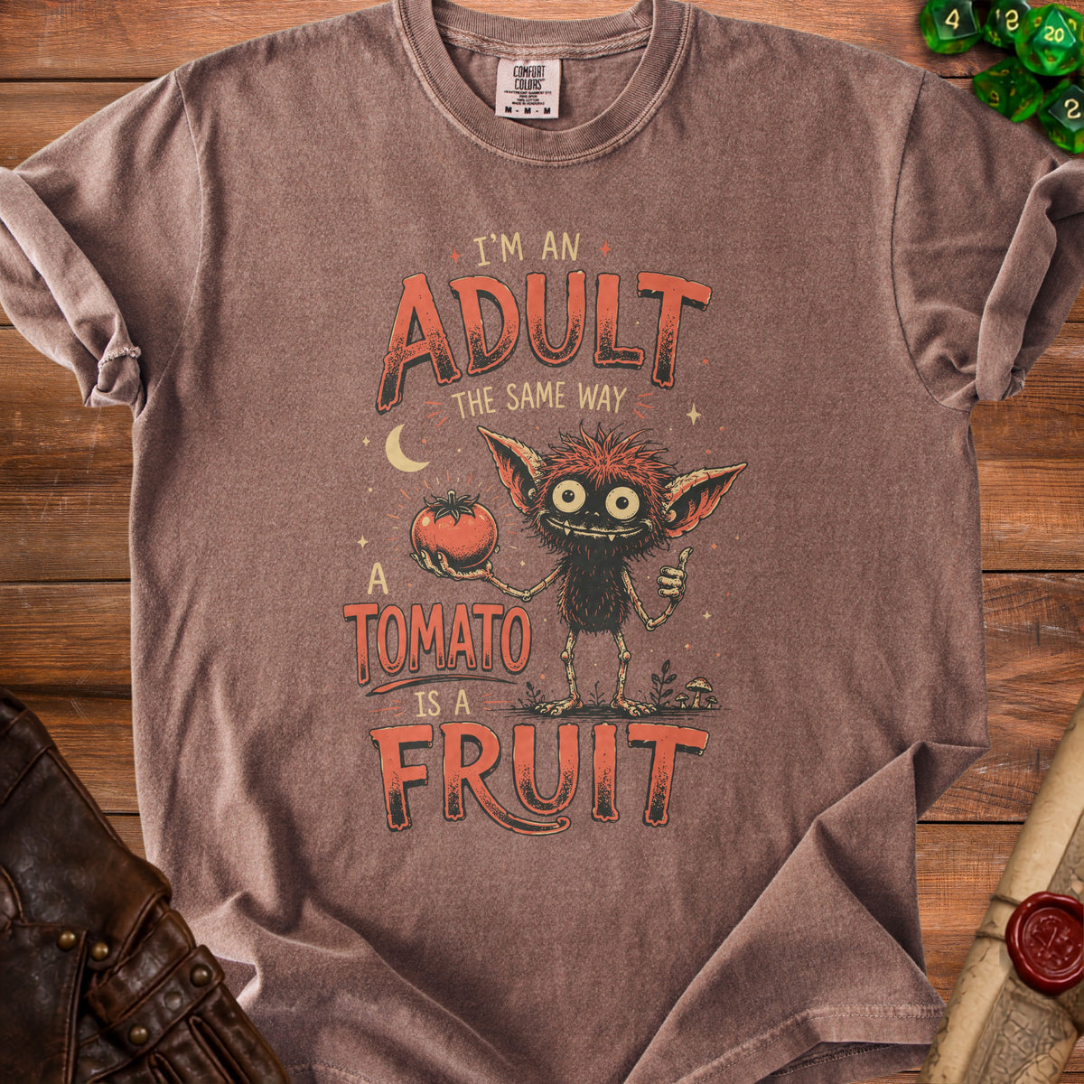 Brown t-shirt with text "I'm an adult the same way a tomato is a fruit."