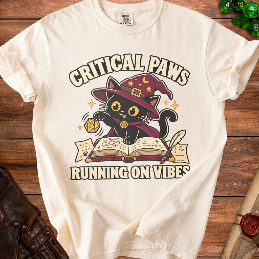 Cream t-shirt with a black cat wearing a wizard hat and "Critical Paws Running on Vibes" text.