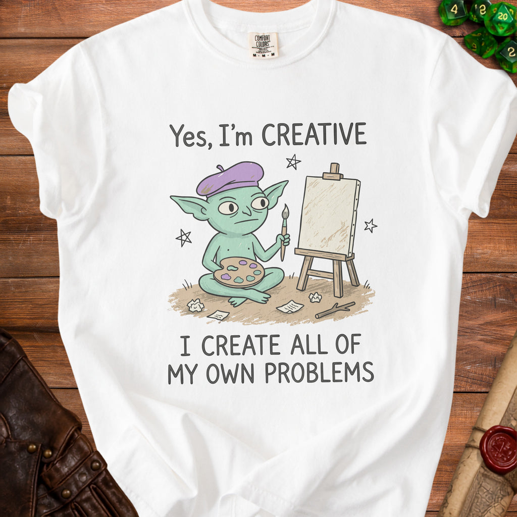 White t-shirt with a cartoon goblin artist and the text "Yes, I'm CREATIVE I CREATE ALL OF MY OWN PROBLEMS".