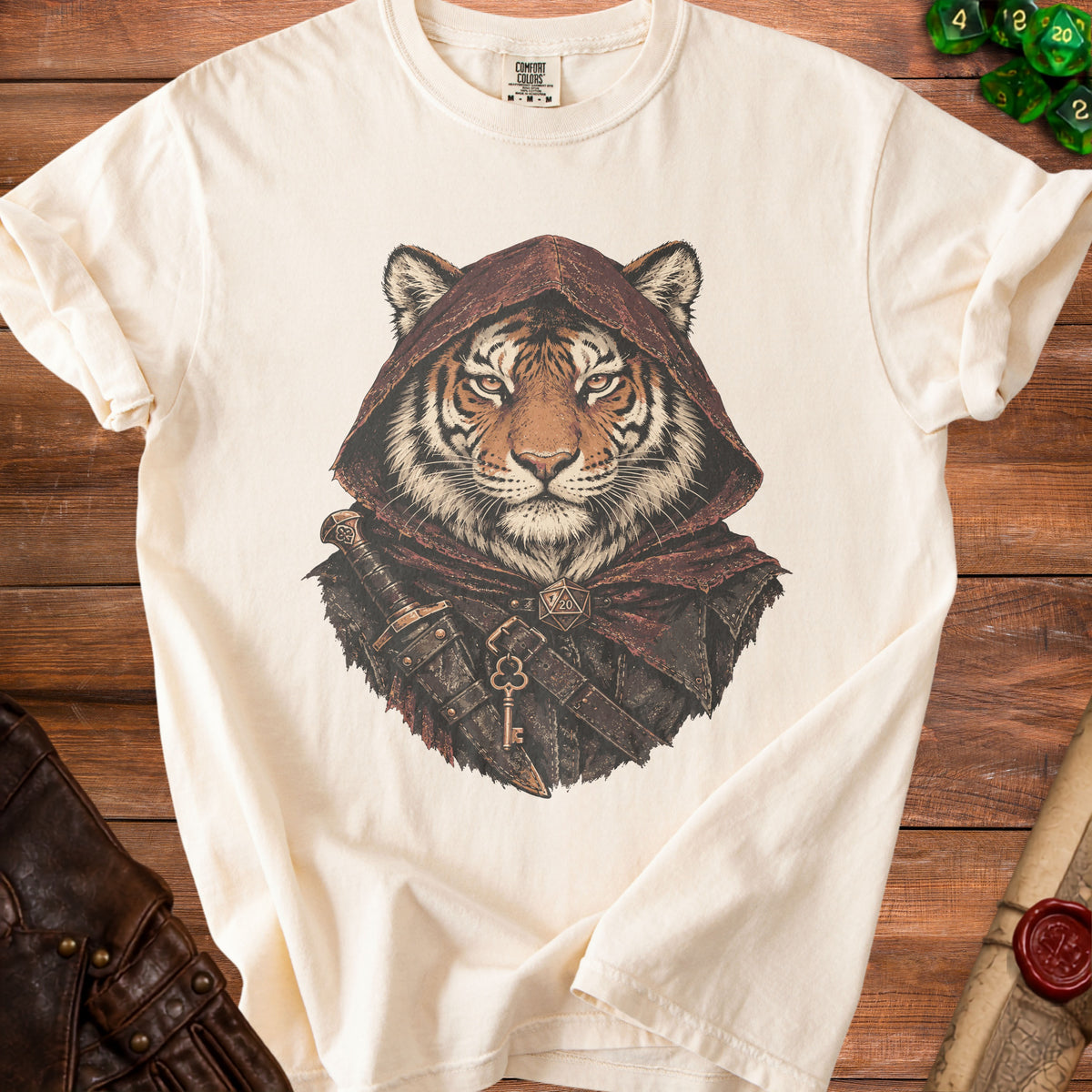 Beige crewneck t-shirt featuring a fantasy graphic of a tiger wearing a hooded cloak with a dagger and key.