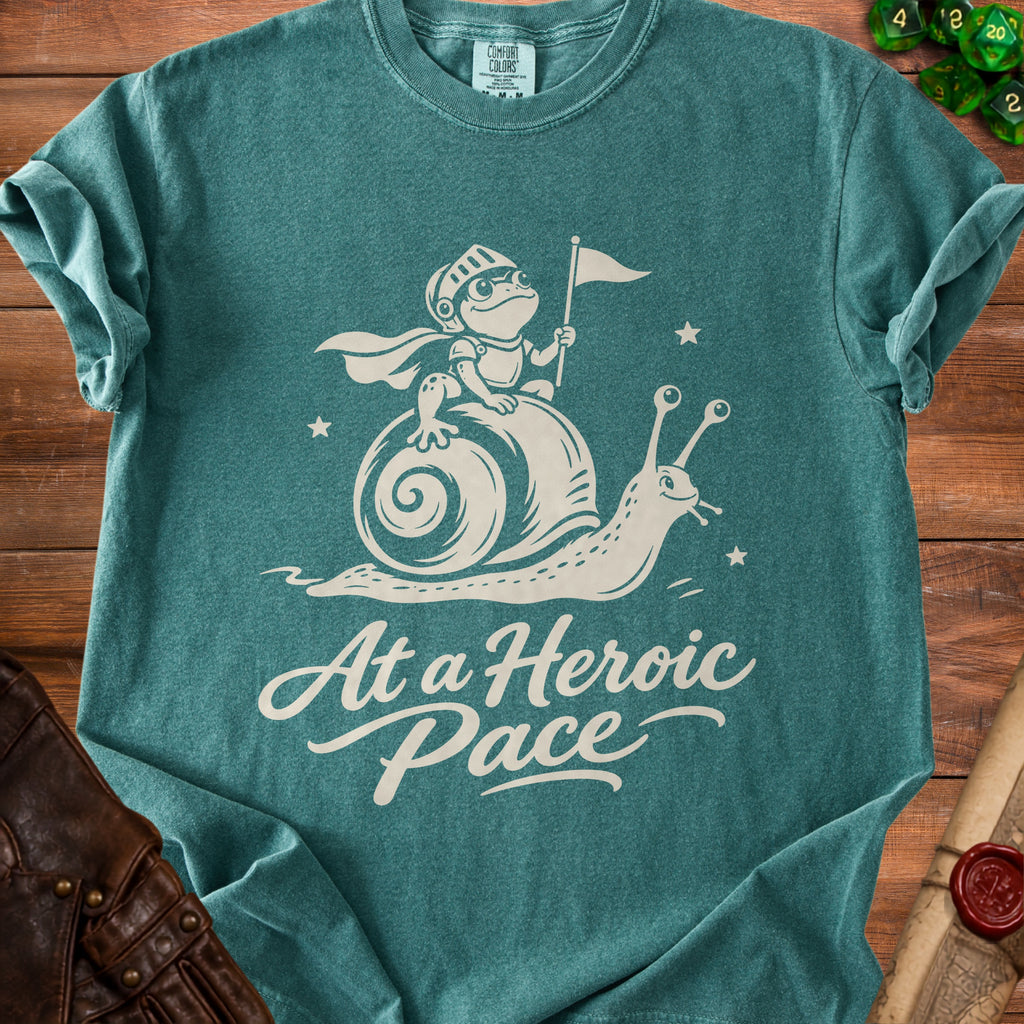 Teal t-shirt with a frog knight riding a snail, saying "At a Heroic Pace".