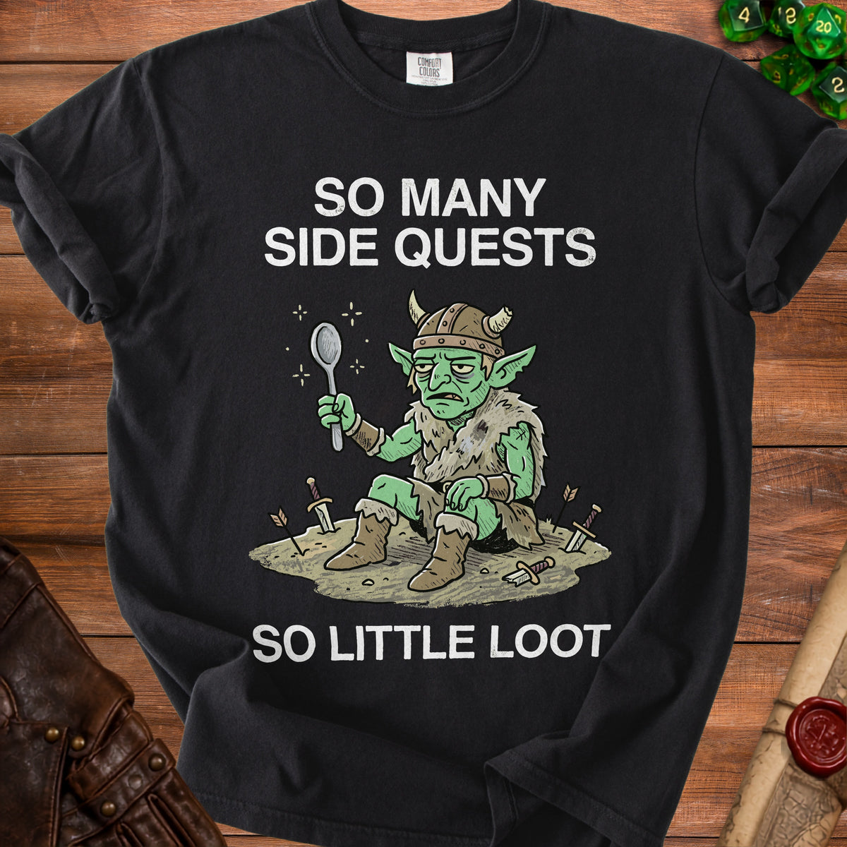 Black t-shirt with a cartoon goblin holding a spoon, text says "SO MANY SIDE QUESTS SO LITTLE LOOT".