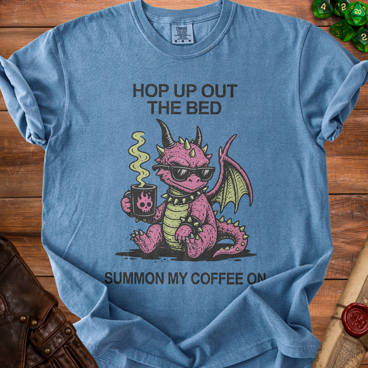 Blue t-shirt with pink dragon wearing sunglasses, holding coffee, and text "Hop up out the bed Summon my coffee on."