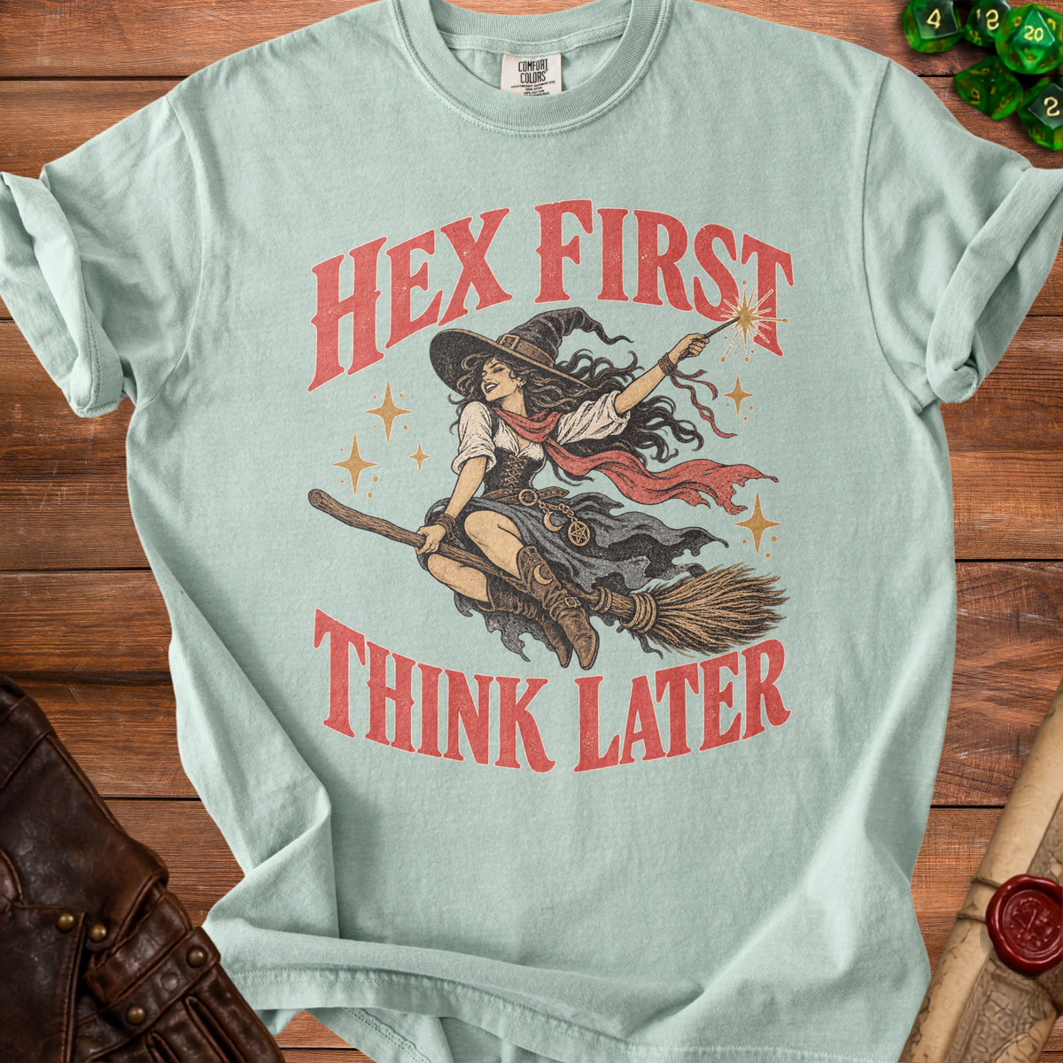 Light blue t-shirt with a witch riding a broomstick and the text "HEX FIRST THINK LATER".