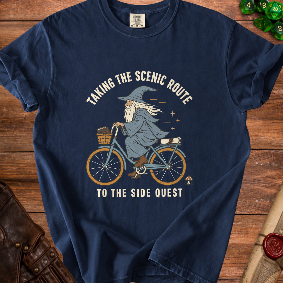 T-shirt graphic of wizard riding bicycle with text "Taking the Scenic Route to the Side Quest".