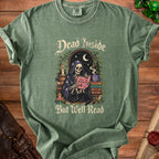 Green t-shirt with skeleton reading surrounded by books and a cat.
