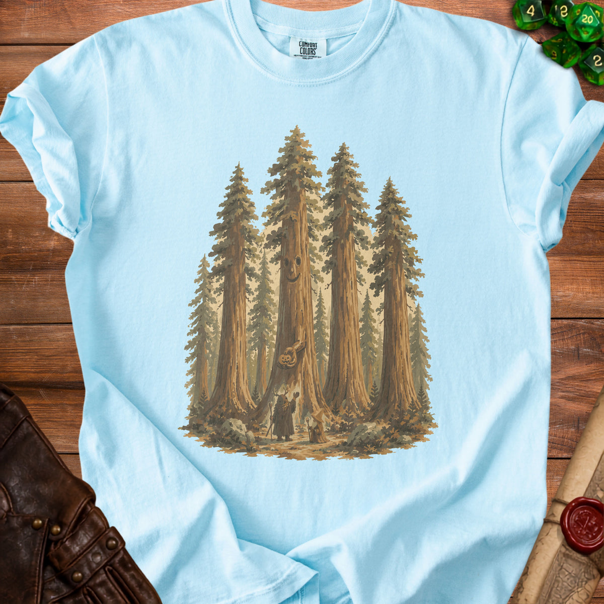 Light blue t-shirt with a graphic of wizards and a jack-o'-lantern in a redwood forest.