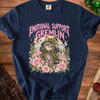 "Emotional Support Gremlin" text over a cat in a mushroom hat, surrounded by flowers and crystals.