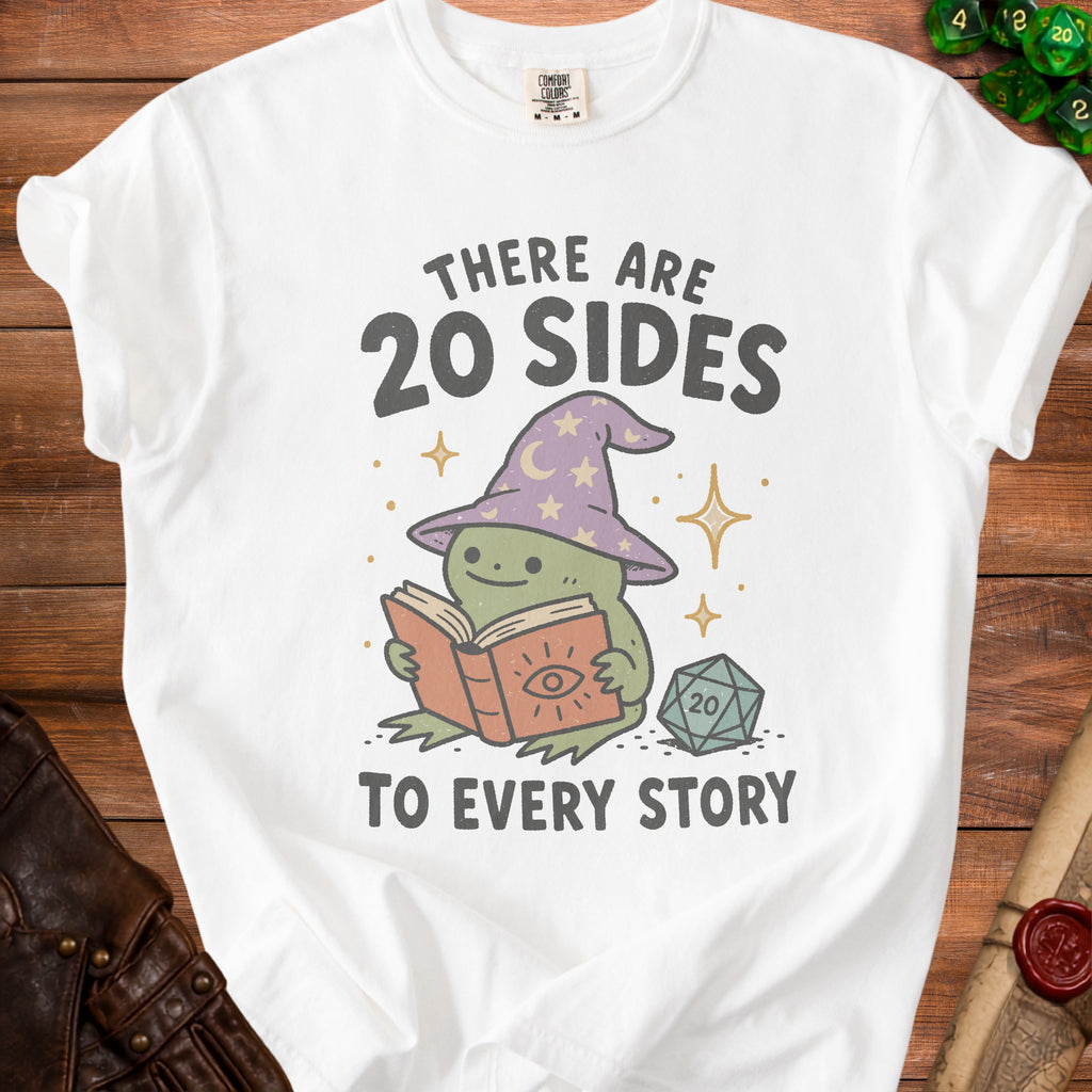 White t-shirt with a graphic of a frog reading a book and a D20 die.