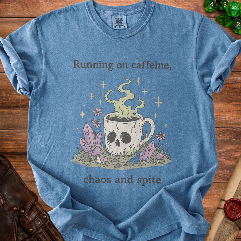 Blue t-shirt graphic with skull mug, crystals, and text "Running on caffeine, chaos and spite."
