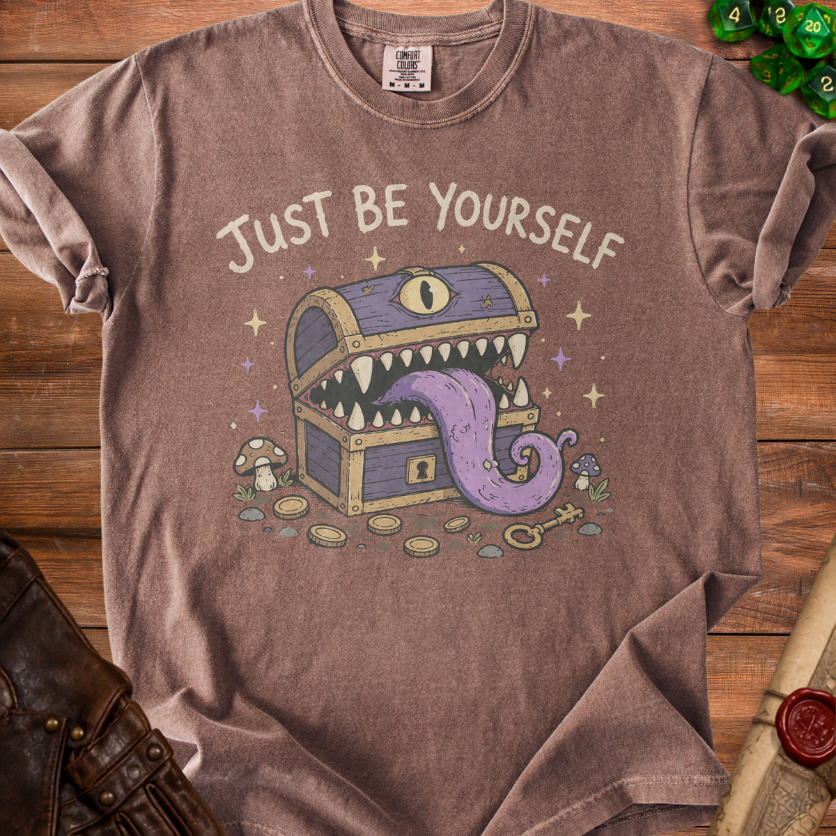 Brown t-shirt with "Just Be Yourself" and a monster treasure chest graphic.