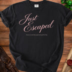 A black t-shirt printed with the pink text Just Escaped from an entirely optional gathering.