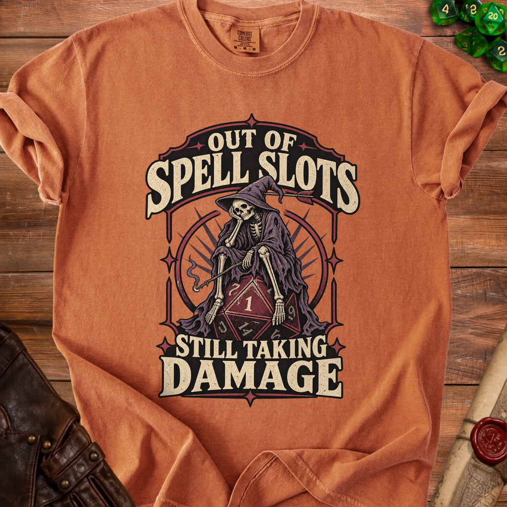 Orange t-shirt graphic featuring skeleton wizard, a d20 die, and text "Out of Spell Slots Still Taking Damage".